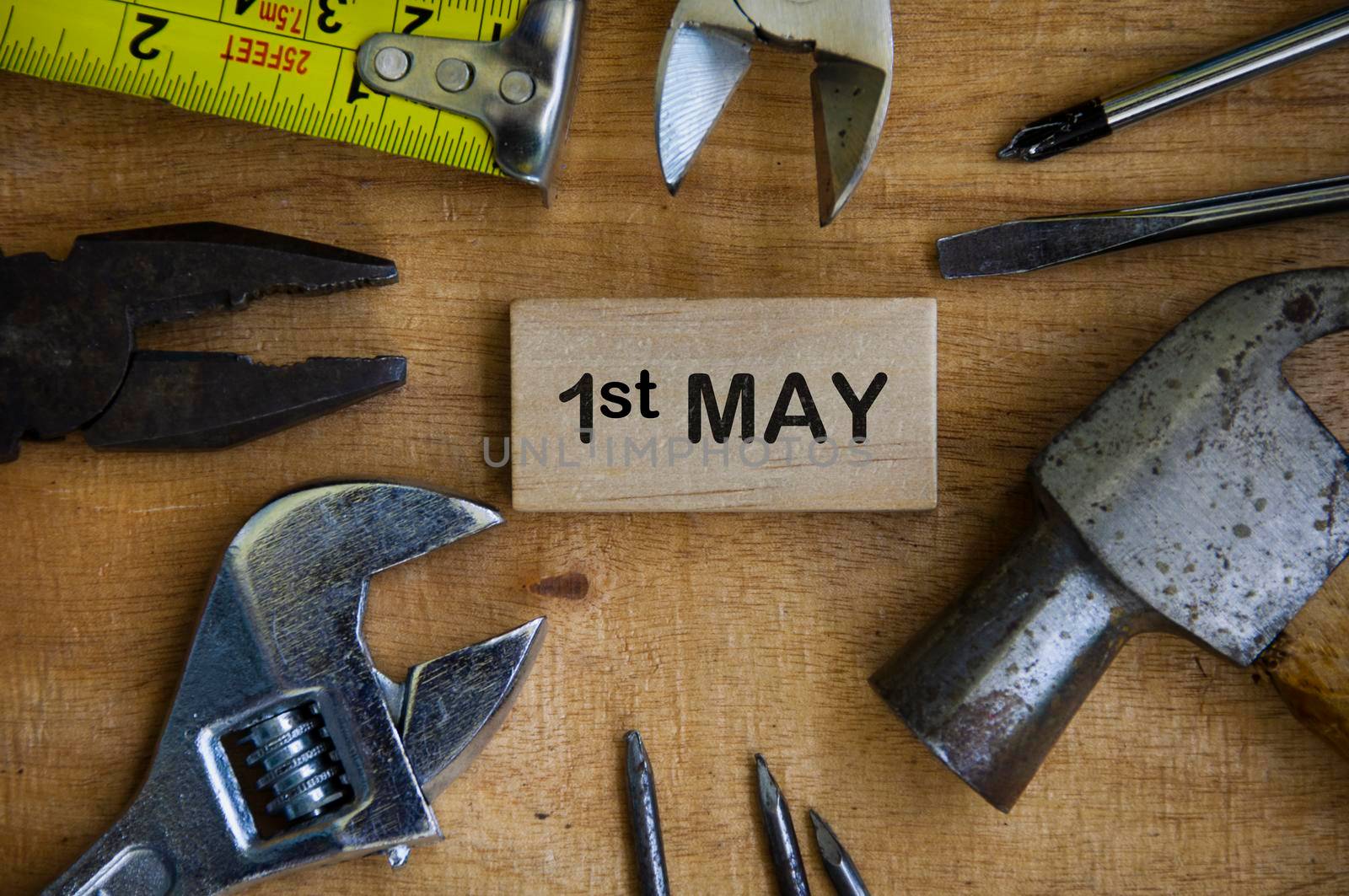 Text on wooden block - 1st May with working tools background. Labor day concept.