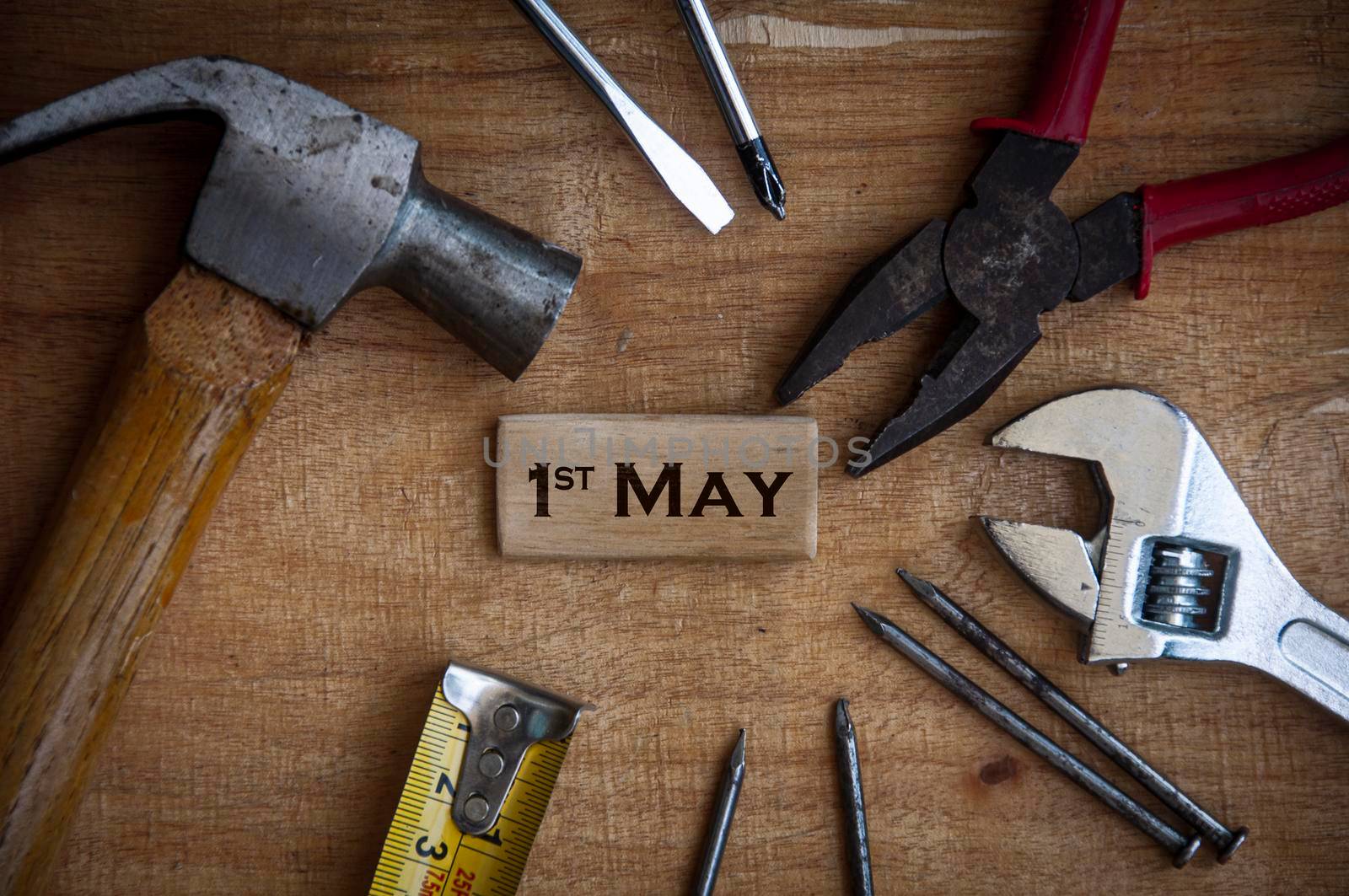 Text on wooden block - 1st May with working tools background. Labor day concept.