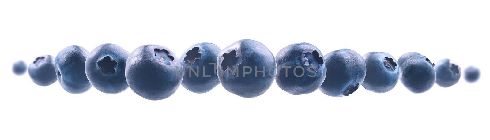 Ripe blueberries levitate on a white background.