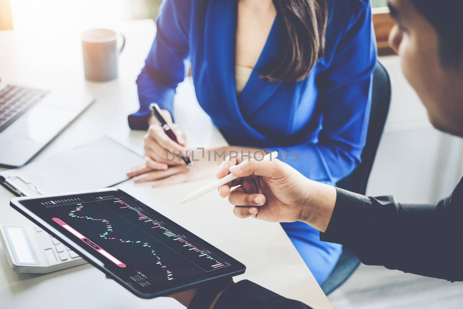 Risk Management Concept, Male stock marketer is using tablet to teach women how to invest in stocks to plan for stock market risk