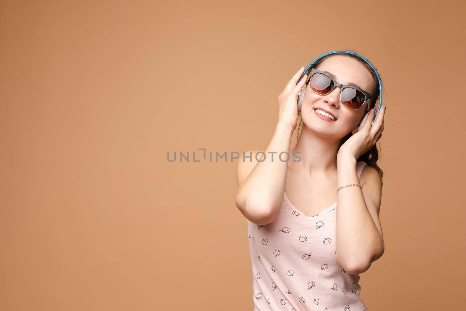 A woman in bright clothes, a T-shirt and denim shorts, sunglasses