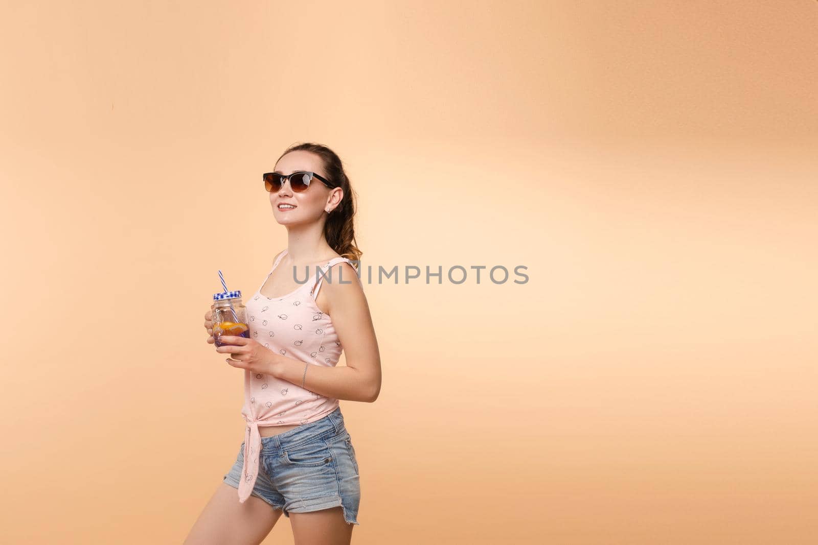 A woman in bright clothes, a T-shirt and denim shorts, sunglasses
