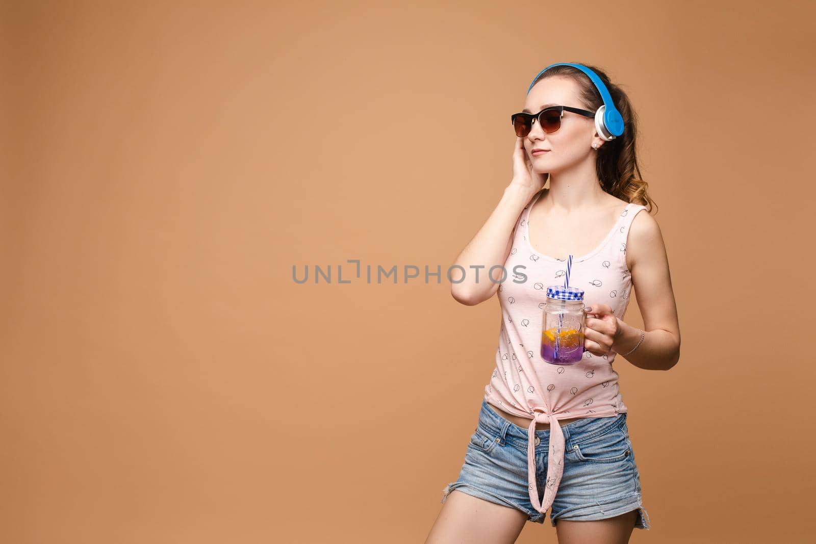 A woman in bright clothes, a T-shirt and denim shorts, sunglasses