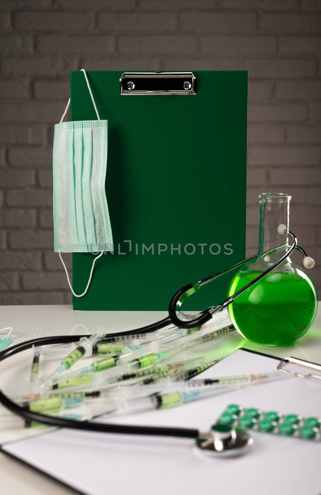 the medical mask , syringes and other medical instruments of the virologist's doctor are on the table