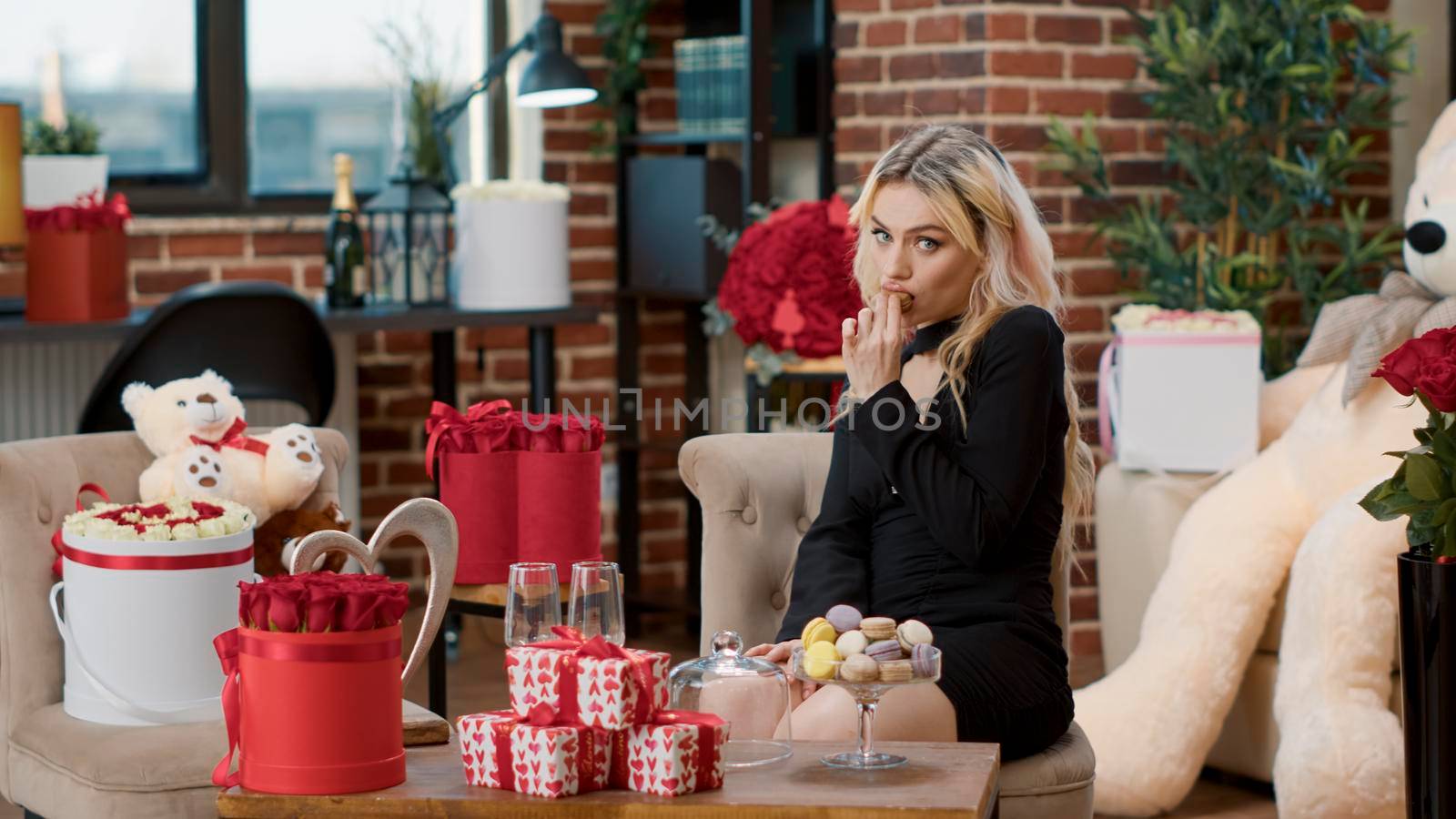 Sensual blonde woman eating macarons sweets on valentines day by DCStudio