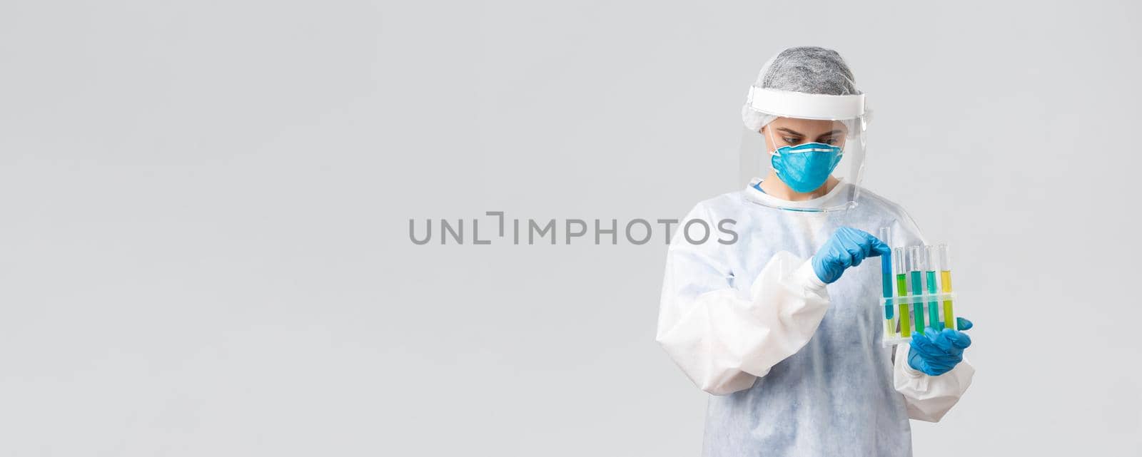 Covid-19, medical research, diagnosis, healthcare workers and quarantine concept. Doctor work clinical lab, test-tubes coronavirus vaccine samples, holding ampoules, wear personal protective suit by Benzoix