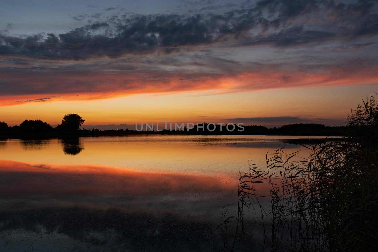 Reflection of clouds in the water after sunset, summer evening