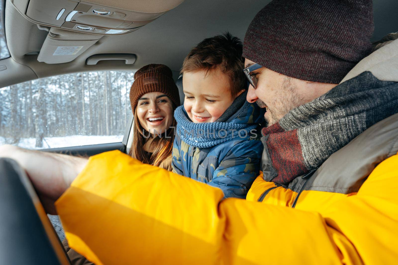 Mother, father and child traveling by car on a vacation to the mountains in winter, close up