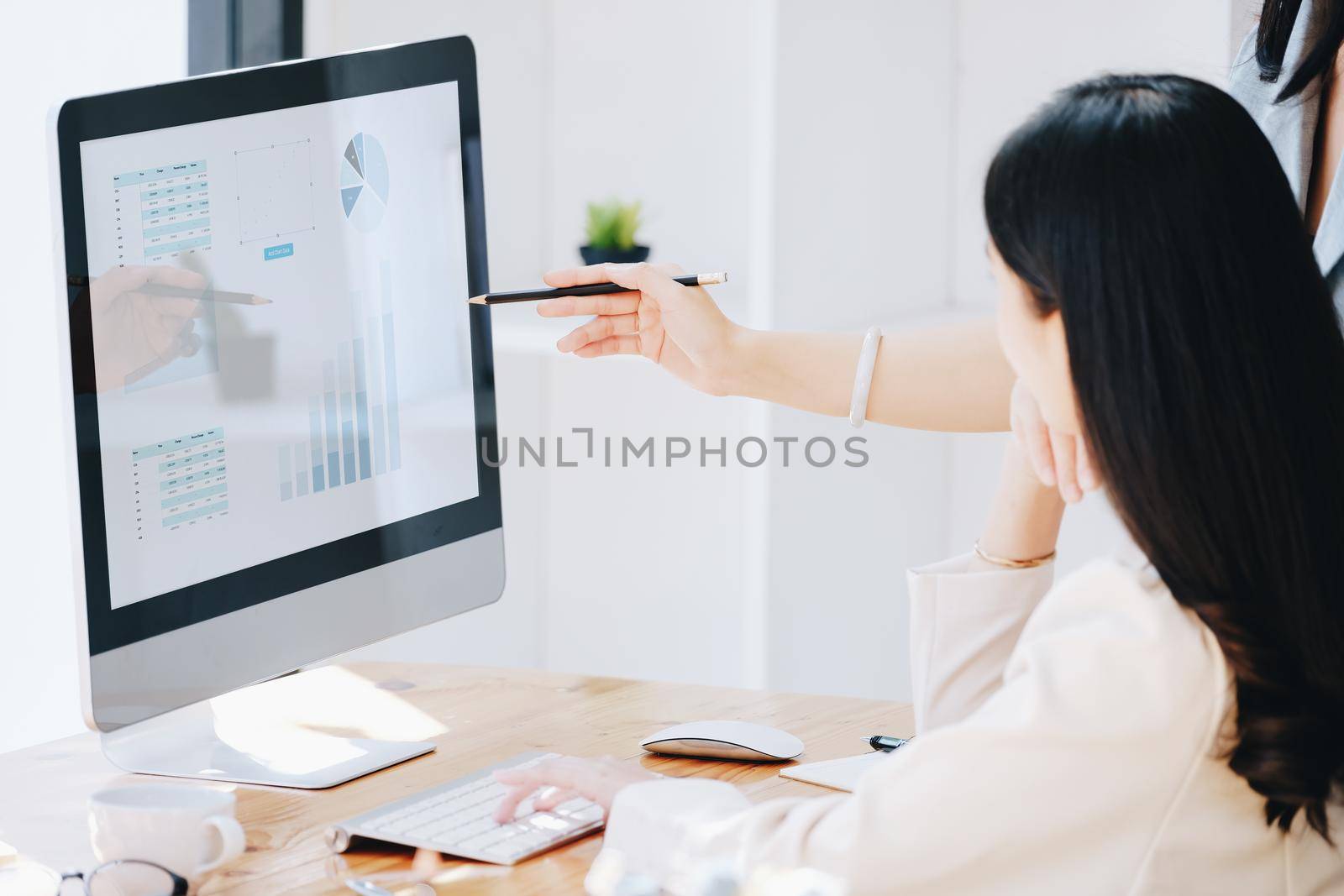 Consultation, Discussion, Marketing and Investment concept, female employee with pen is pointing at computer monitor to colleagues to draw conclusions and assess investment risks for the company