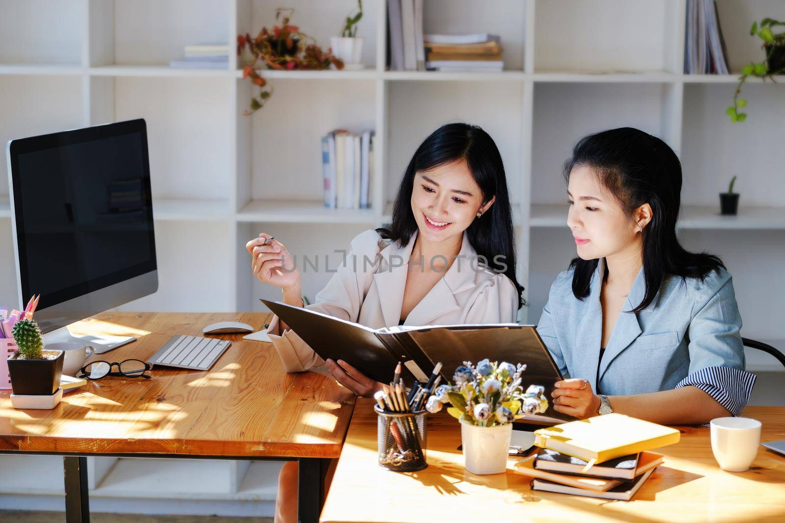 Consultation concept, contract signing, insurance, female employee holding a pen is offering contract documents to customers to sign important documents. by Manastrong