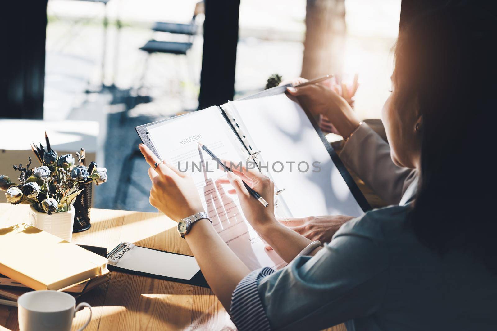 Consultation concept, contract signing, insurance, female employee holding a pen is offering contract documents to customers to sign important documents. by Manastrong