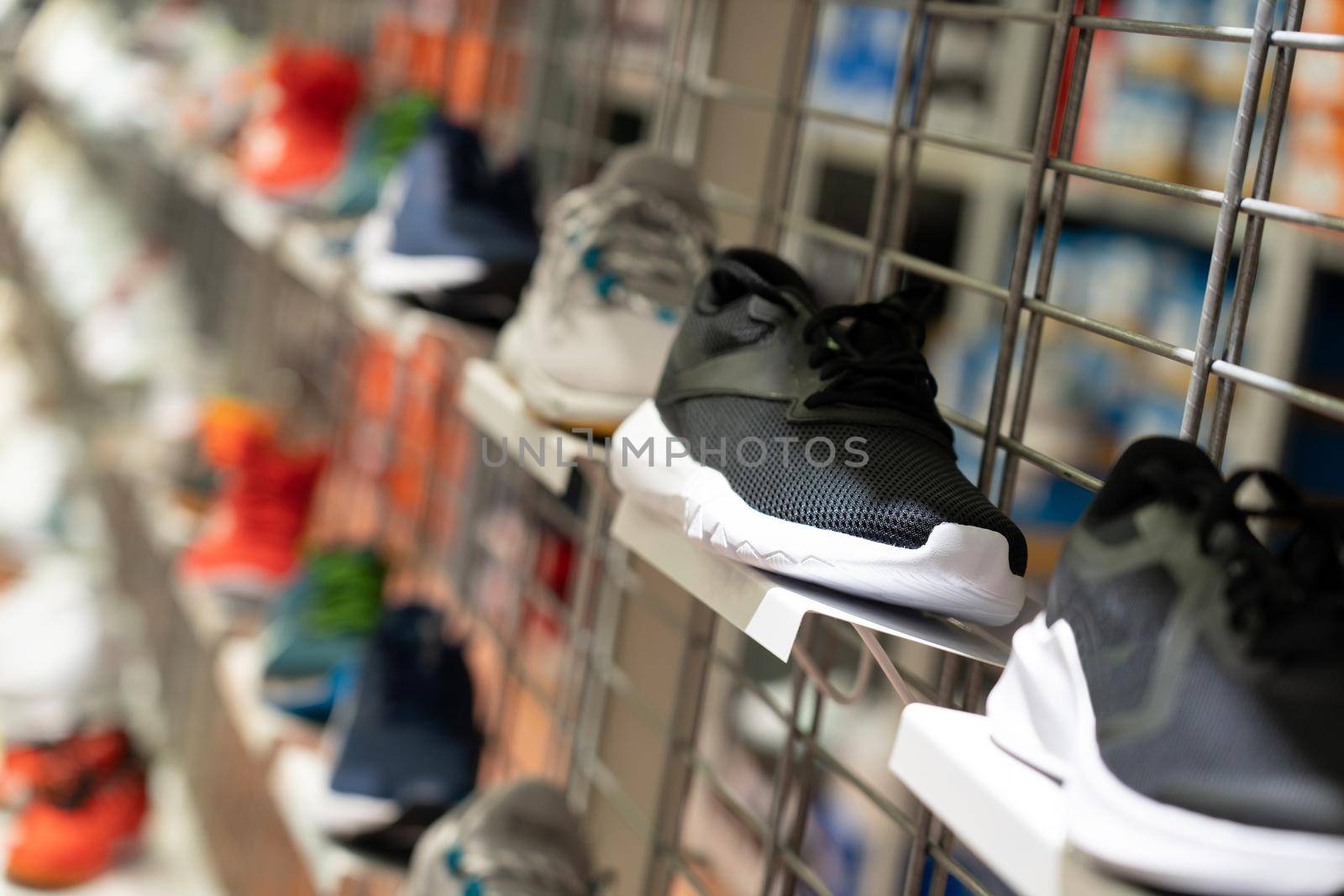 Abstract blur sport shoes on shelves in sneakers shop background. Many Sport shoes sale on the shelf in a supermarket, as blurred effect background.