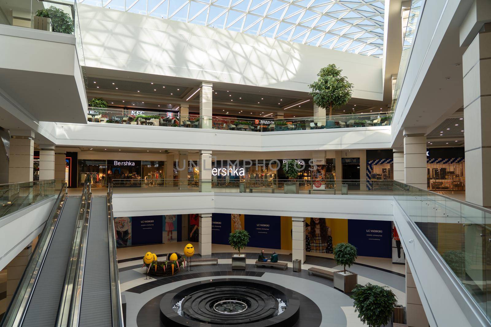 Grodno, Belarus - April 07, 2021: The interior of the modern large shopping and entertainment complex Trinity with a transparent glass roof.