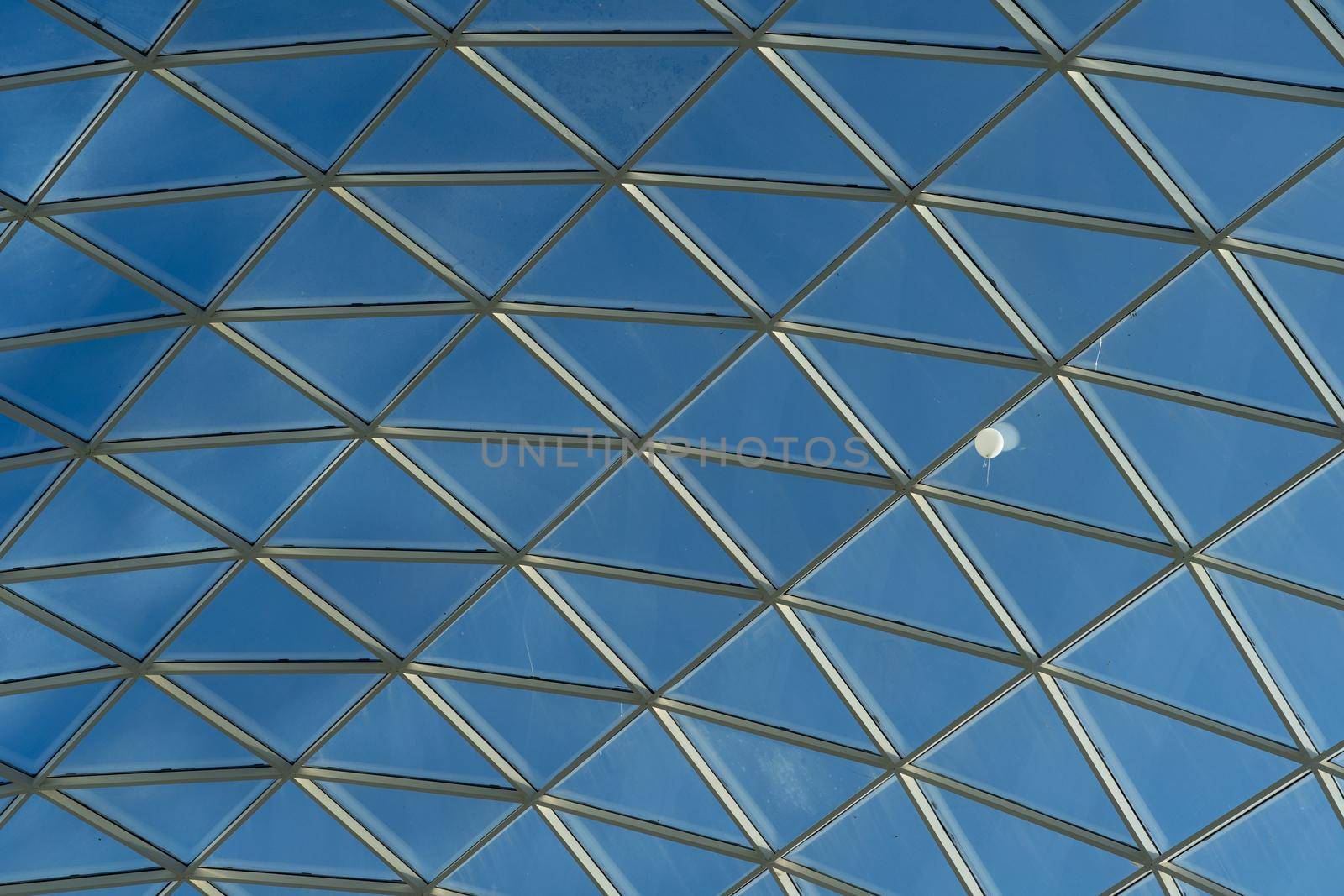 Transparent glass roof of a modern shopping center and a white balloon under it