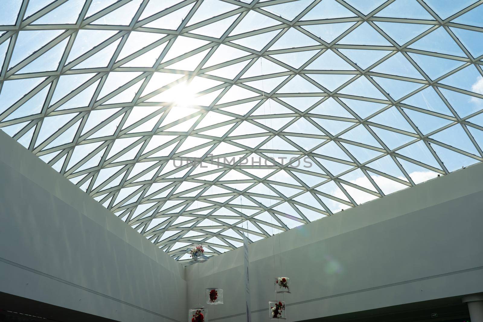 Transparent glass roof of a modern shopping center with sunlight