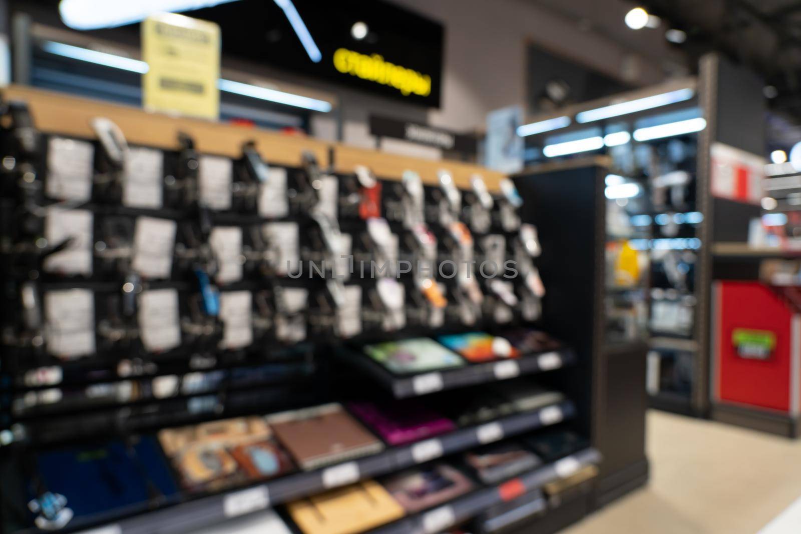 Showcase with smartphones in the modern electronics store. Buy a mobile phone. Many smartphones on the shelf of the technology store. Blurred image as a background.