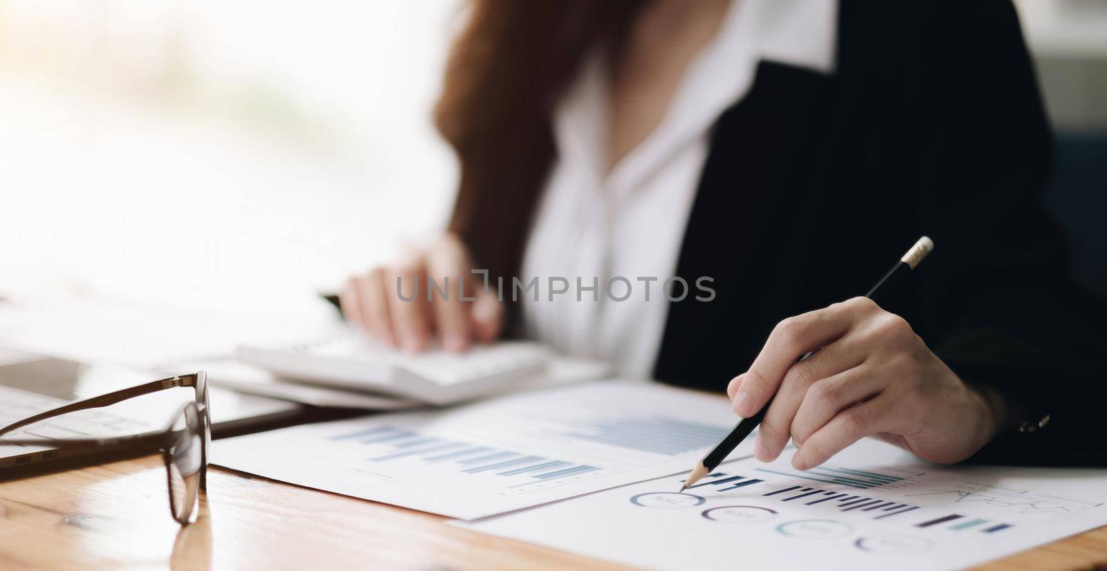 Consult financial concept. Businesswoman pointing at papwework and using calculator.