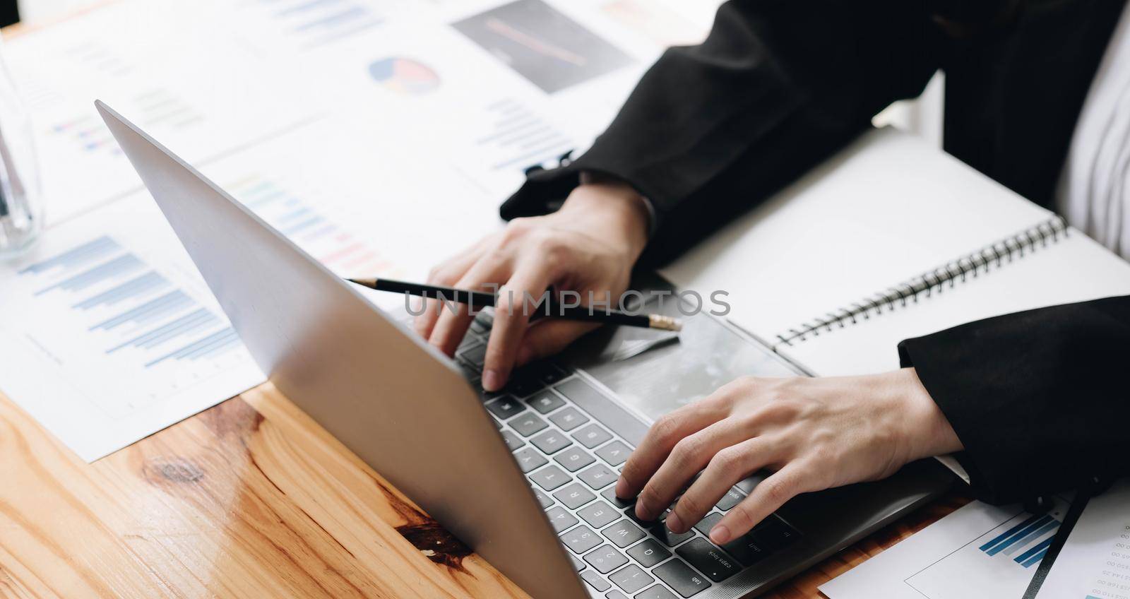 Businesswomen are analyz data from report and laptop computer with finance stock market. finance concept..