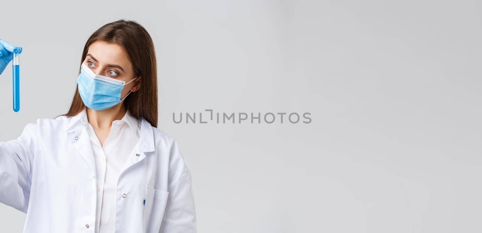 Covid-19, preventing virus, healthcare workers and quarantine concept. Tech lab clinic employee in personal protective equipment, doctor in medical mask researching coronavirus vaccine test-tube by Benzoix