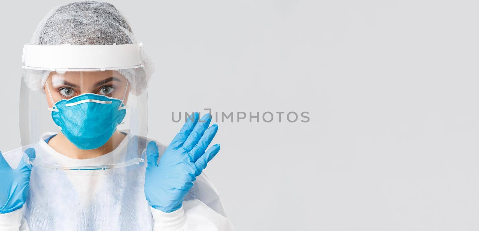 Covid-19, preventing virus, health, healthcare workers and quarantine concept. Close-up female doctor or nurse in personal protective equipment, rubber gloves and respirator showing hands.