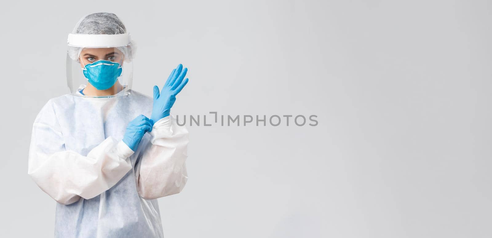 Covid-19, preventing virus, health, healthcare workers and quarantine concept. Serious female doctor in personal protective equipment PPE, shield, face mask out on gloves to enter patient room.