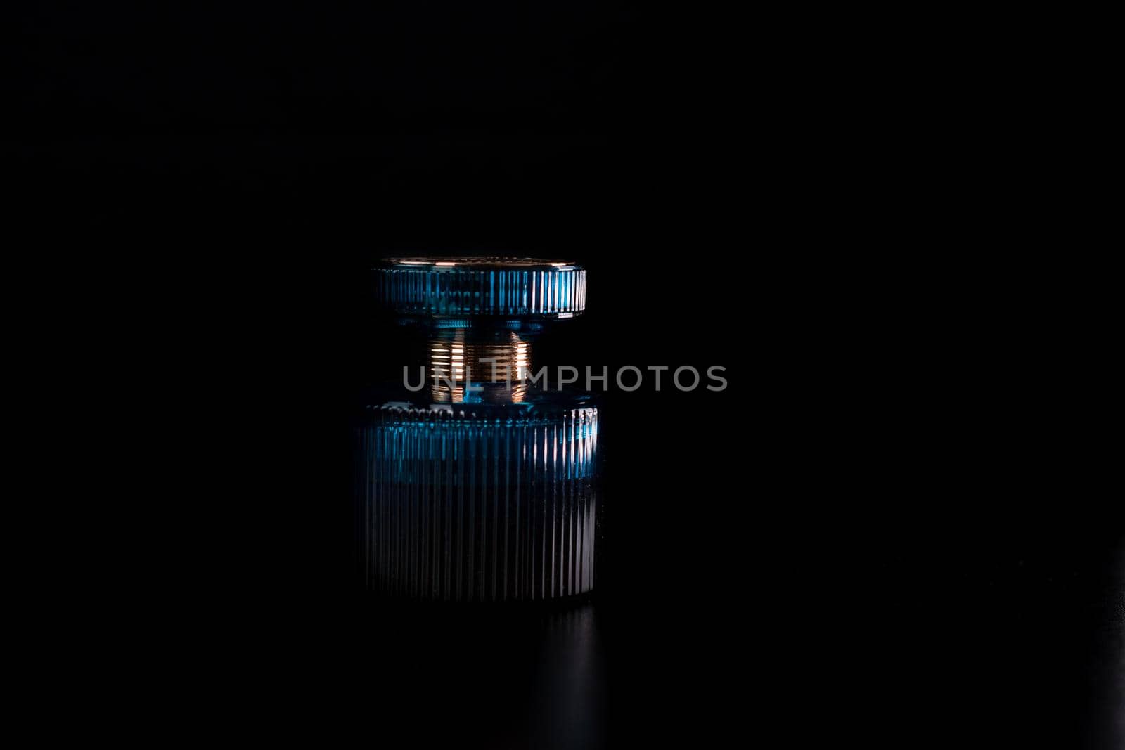 Blue perfume bottle on black background