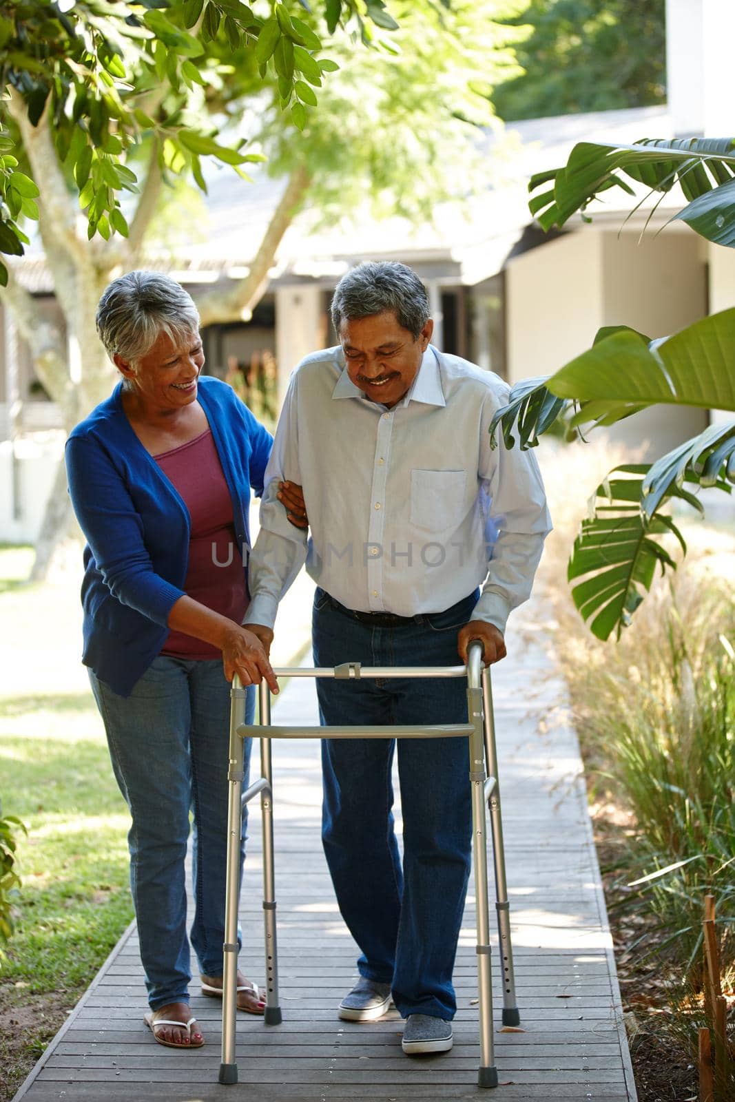 Shot of a senior woman helping her husband adjust to his new walker.