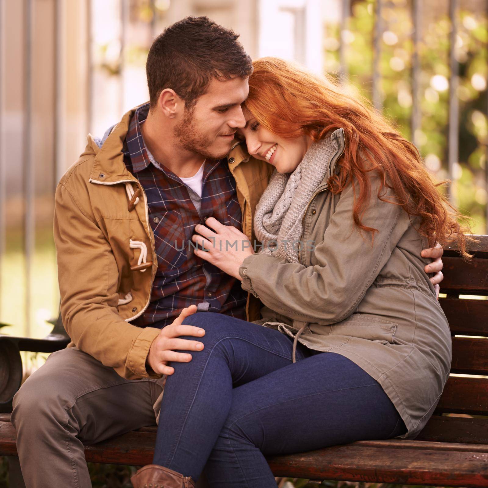Shot of a happy young couple sharing an affectionate moment on a park bench.