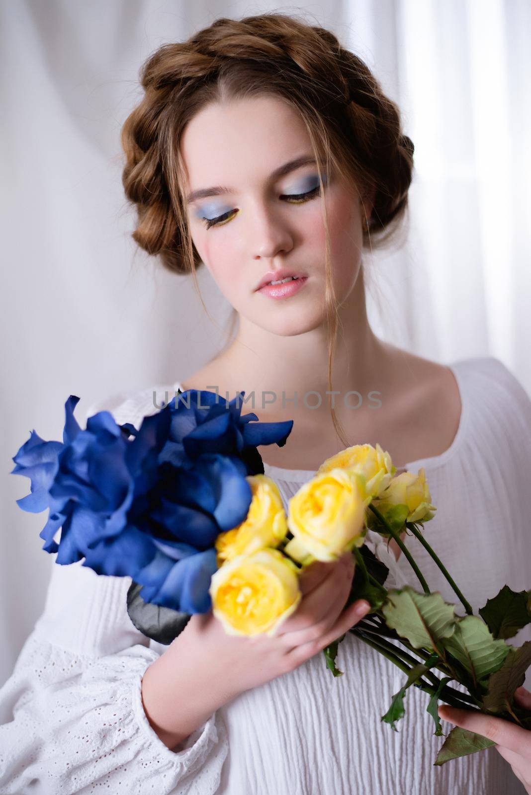 Portrait of caucasian ukrainian girl in white dress and yellow-blue flowers on white background. Calm lady is sleeping. Concept - Stop the war in Ukraine.