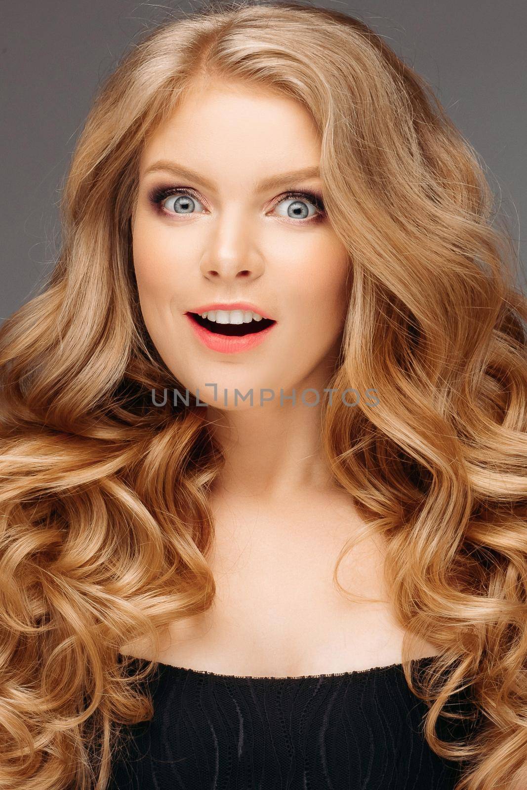 Surprised young woman smiling in studio.