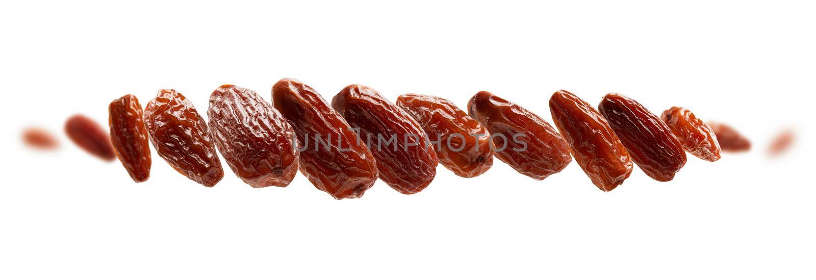 Dried dates levitate on a white background.