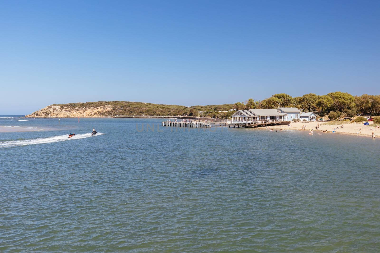 The idyllic Barwon River Beach and Barwon Heads Bridge on a hot summer's day in Barwon Heads, Victoria, Australia