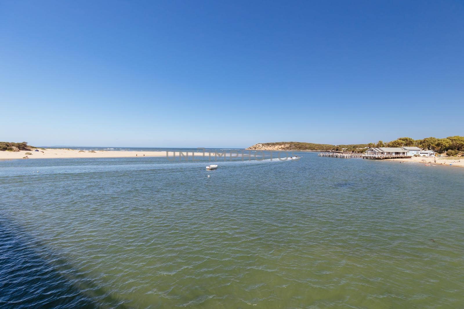 The idyllic Barwon River Beach and Barwon Heads Bridge on a hot summer's day in Barwon Heads, Victoria, Australia
