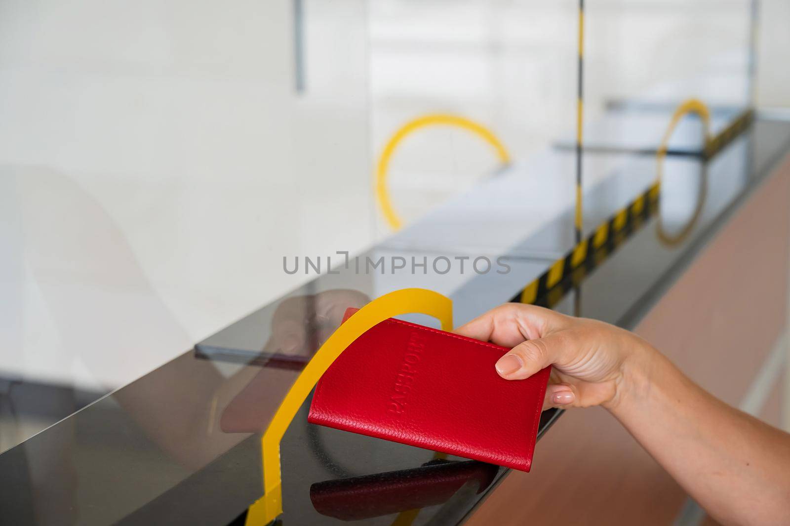 Faceless woman giving her passport at the airport check-in counter. by mrwed54