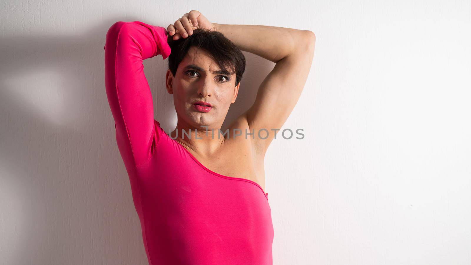 Homosexual in a pink female dress. A man in make-up