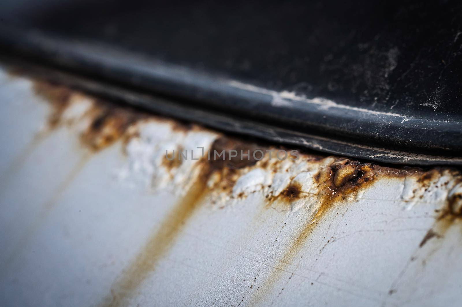 Close-up of rust on a white car. by mrwed54