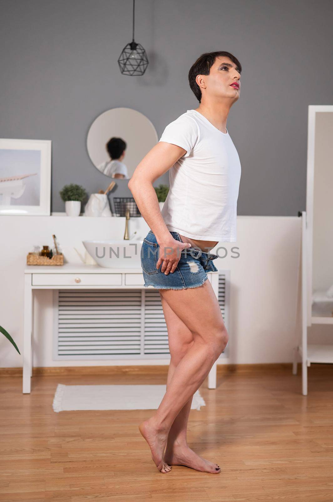 Caucasian gay man takes off his shorts erotically. Gender diversity