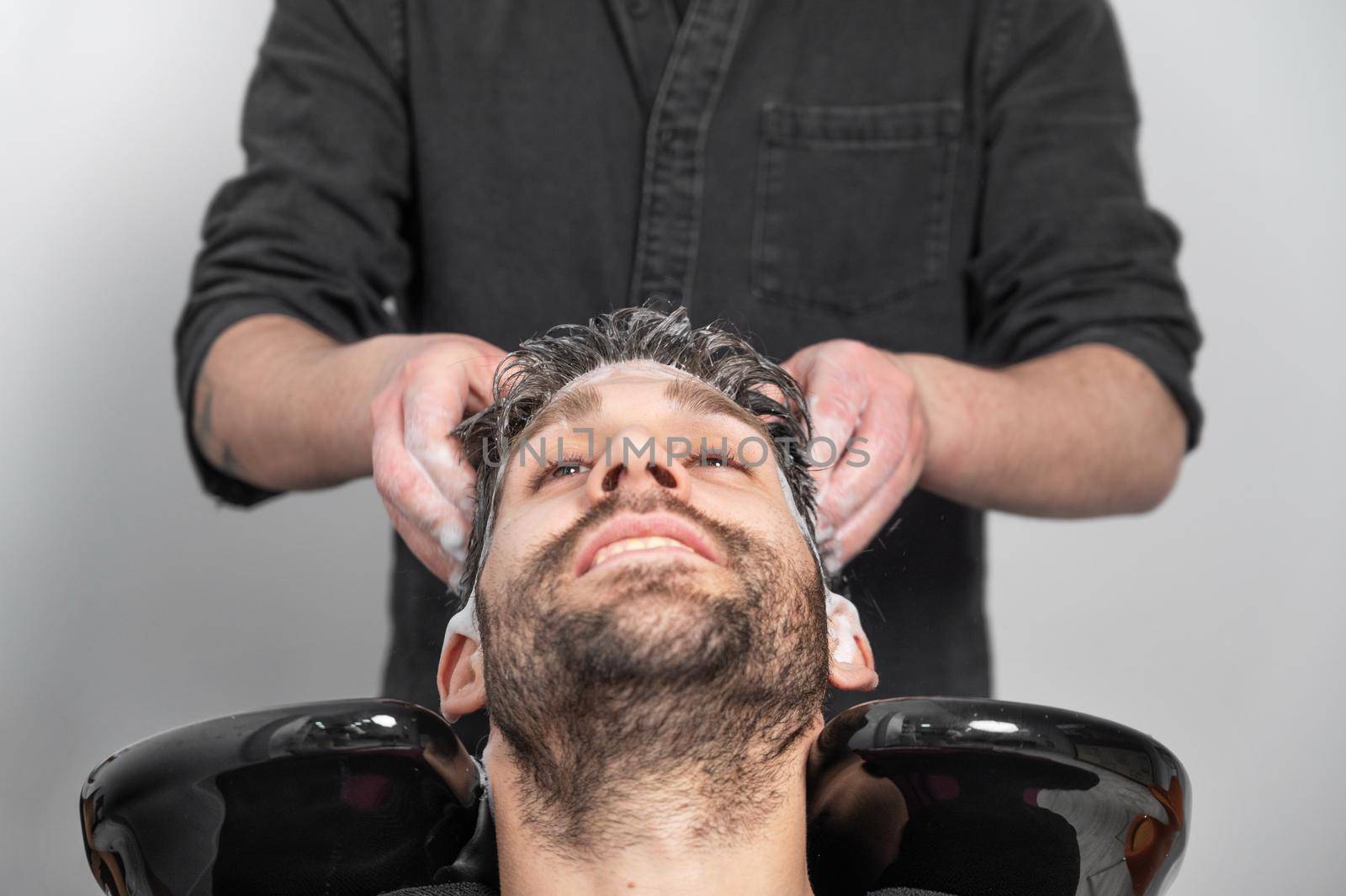 Barber shop. Hairdresser man washes client head in barbershop. High quality photography