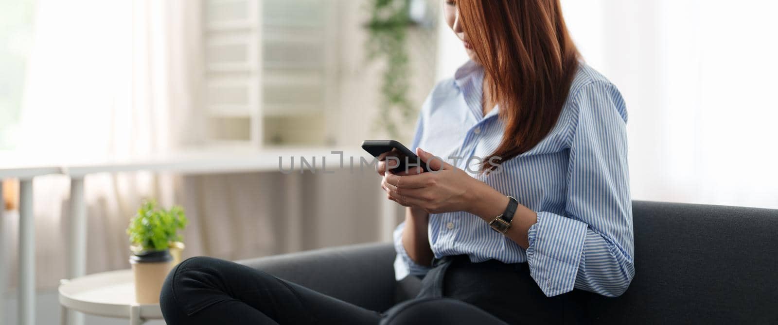 Happy asian girl holding cell phone using smartphone device at home. Smiling young latin woman blogger subscribing new social media, buying in internet, ordering products online in apps. hand close up.