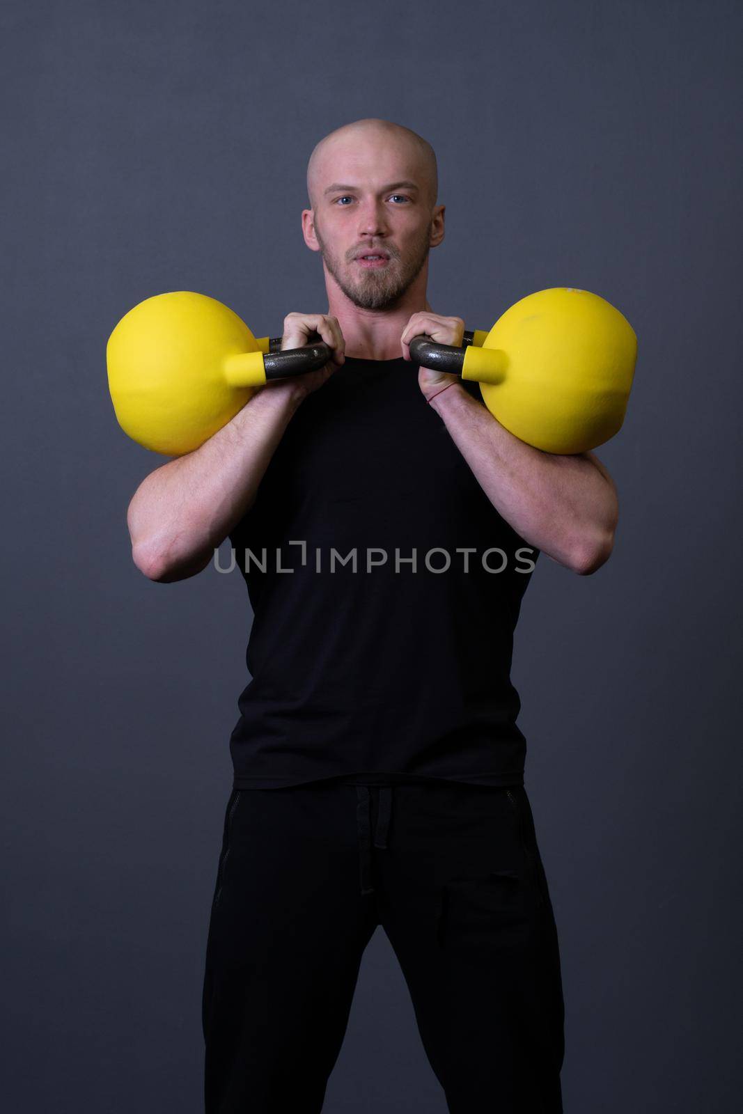 Guy with a yellow kettlebell gym anonymous workout male, in the afternoon motivation effort for picking from up sportswear, southeast filipino. Living bent health, muscle hiit