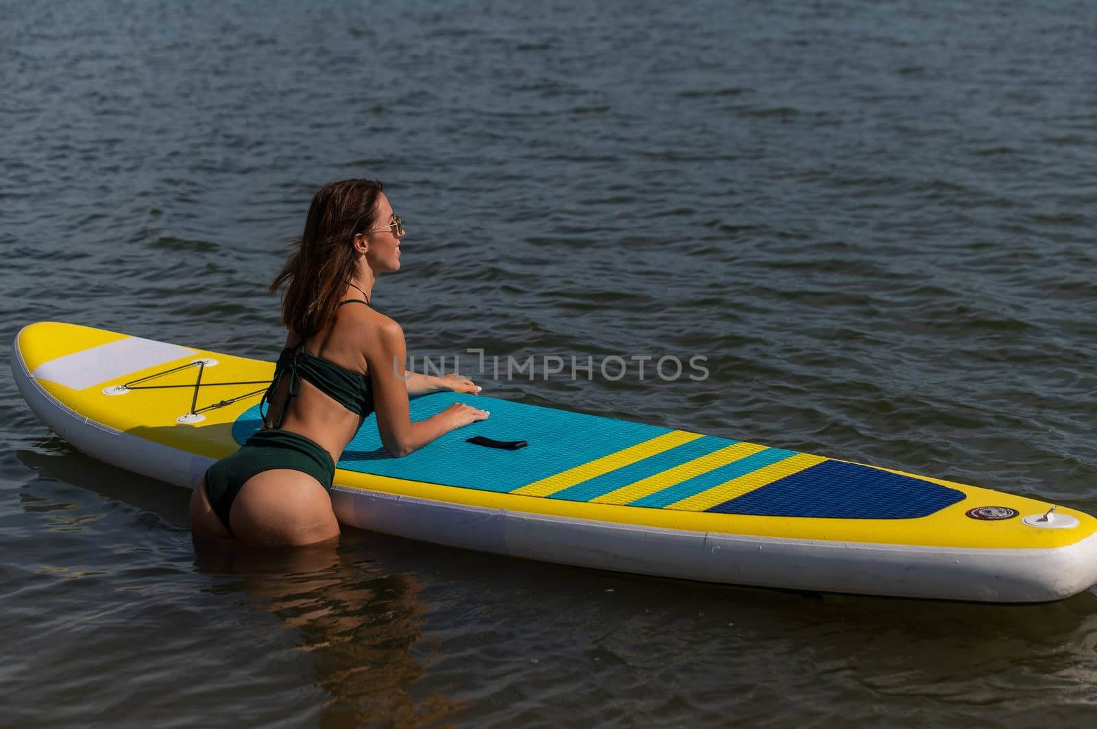 Beautiful caucasian woman is swimming on a SUP board. by mrwed54