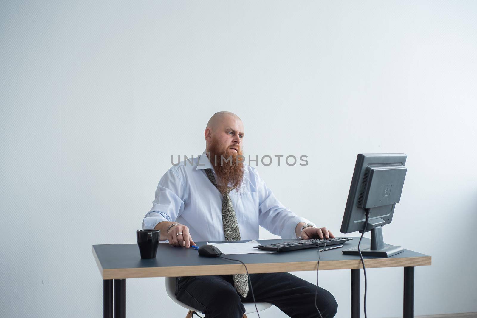 Problems for the office worker. A bald man in a white shirt sits at a desk with a computer and is stressed because of failure. A nervous breakdown. by mrwed54