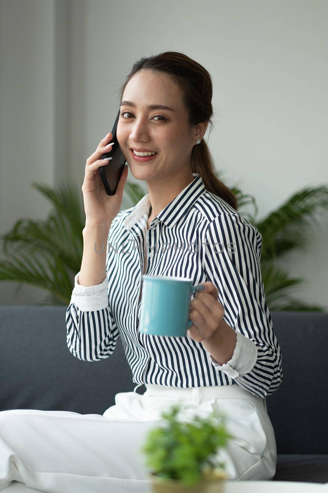 Attractive asian businesswoman talking on mobile phone with client