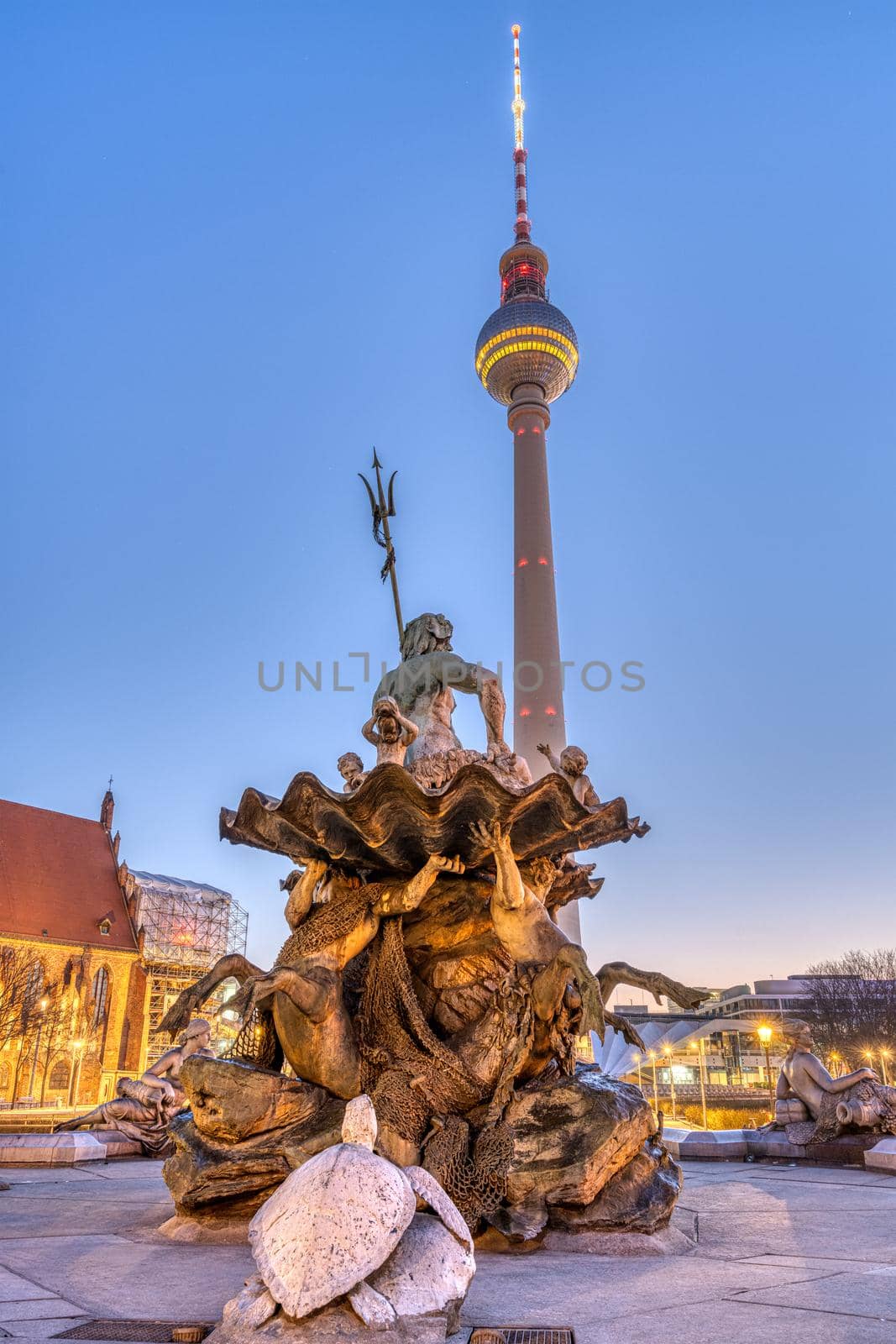 The famous TV Tower and the Neptune fountain in Berlin at twilight