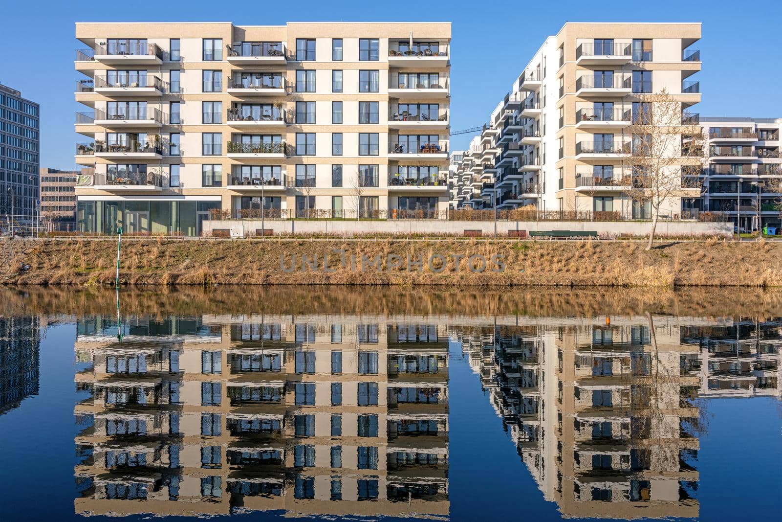New apartment buildings reflecting in a canal seen in Berlin, Germany