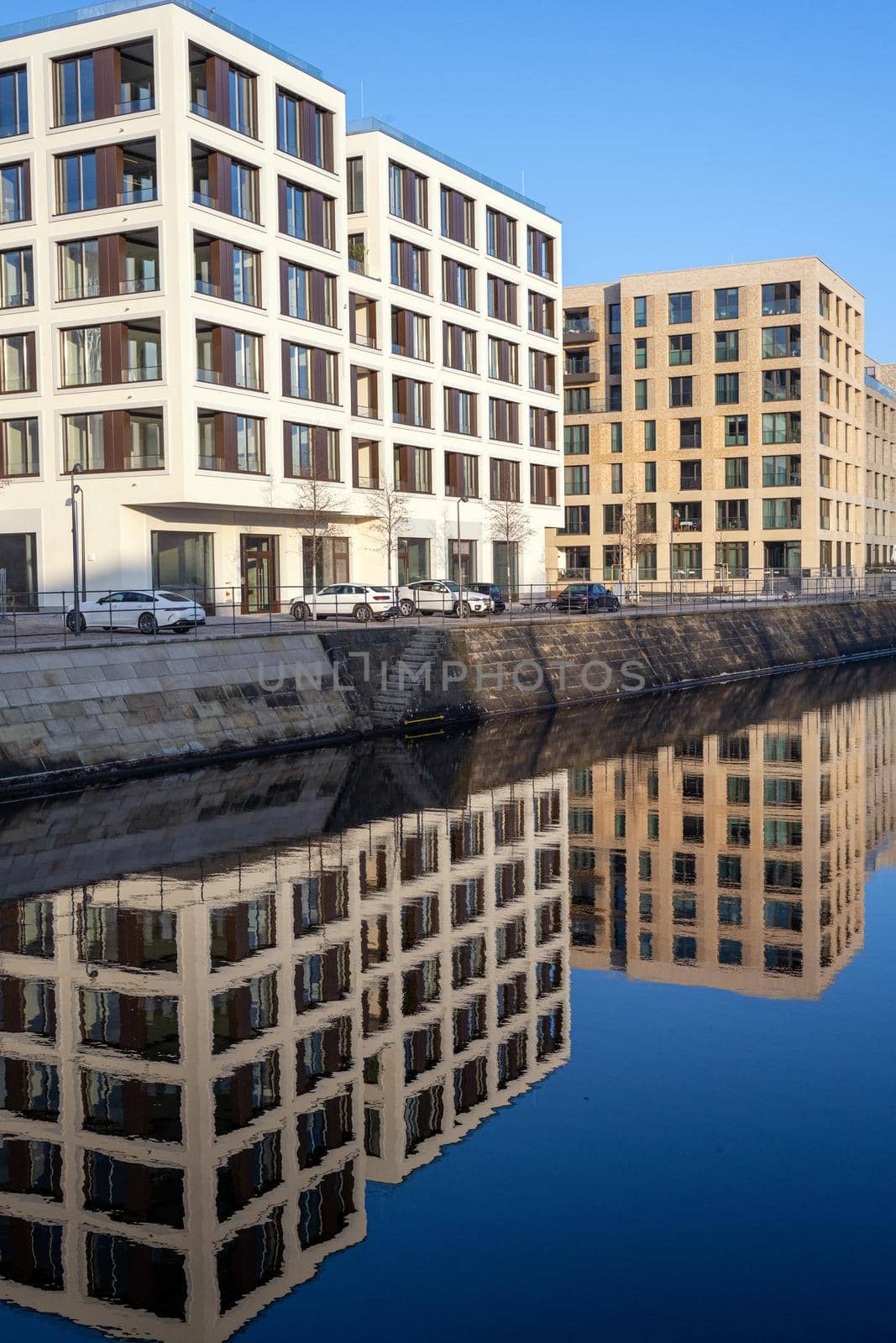 New apartment buildings reflected in a small canal seen in Berlin, Germany