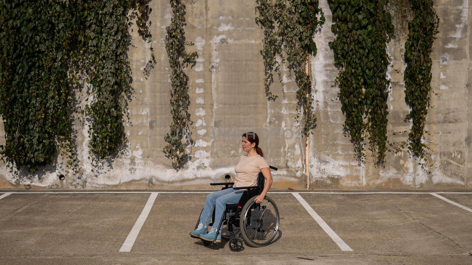Woman riding a wheelchair in a parking lot. by mrwed54