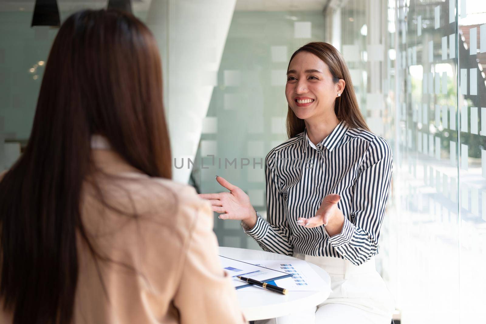 Two asian business woman colleagues meeting to conference professional investor working and discussing a new marketing business strategy project, Business finance and accounting concept.