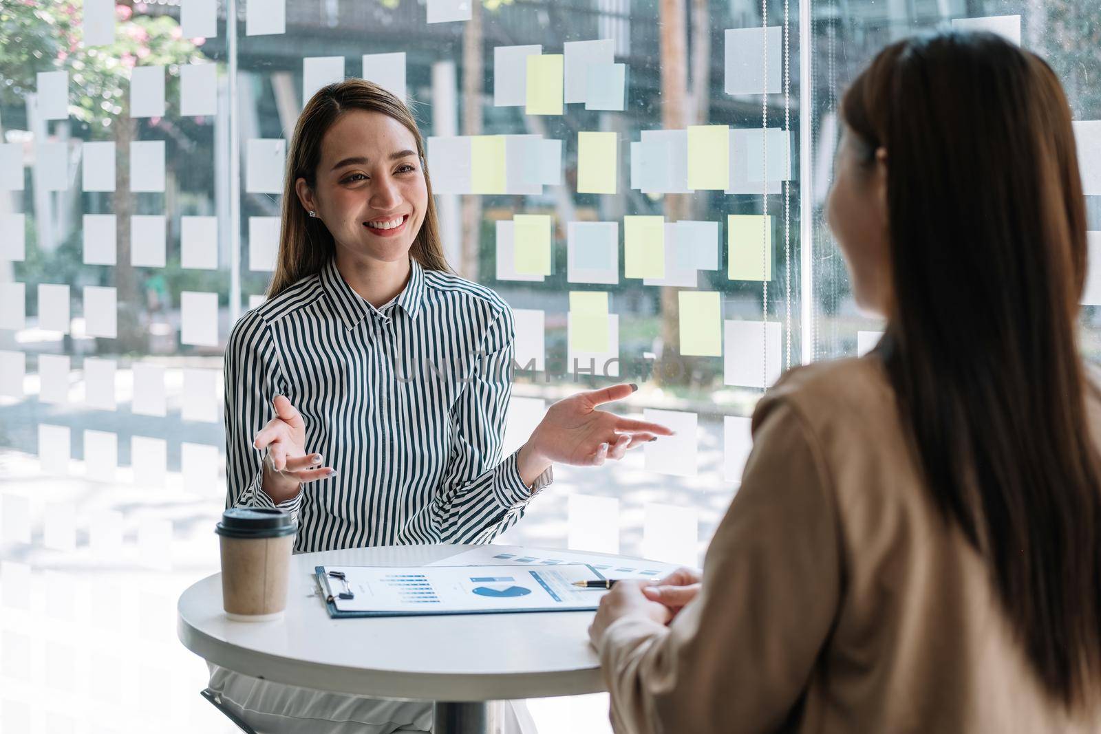 Two asian business woman colleagues meeting to conference professional investor working and discussing a new marketing business strategy project, Business finance and accounting concept.