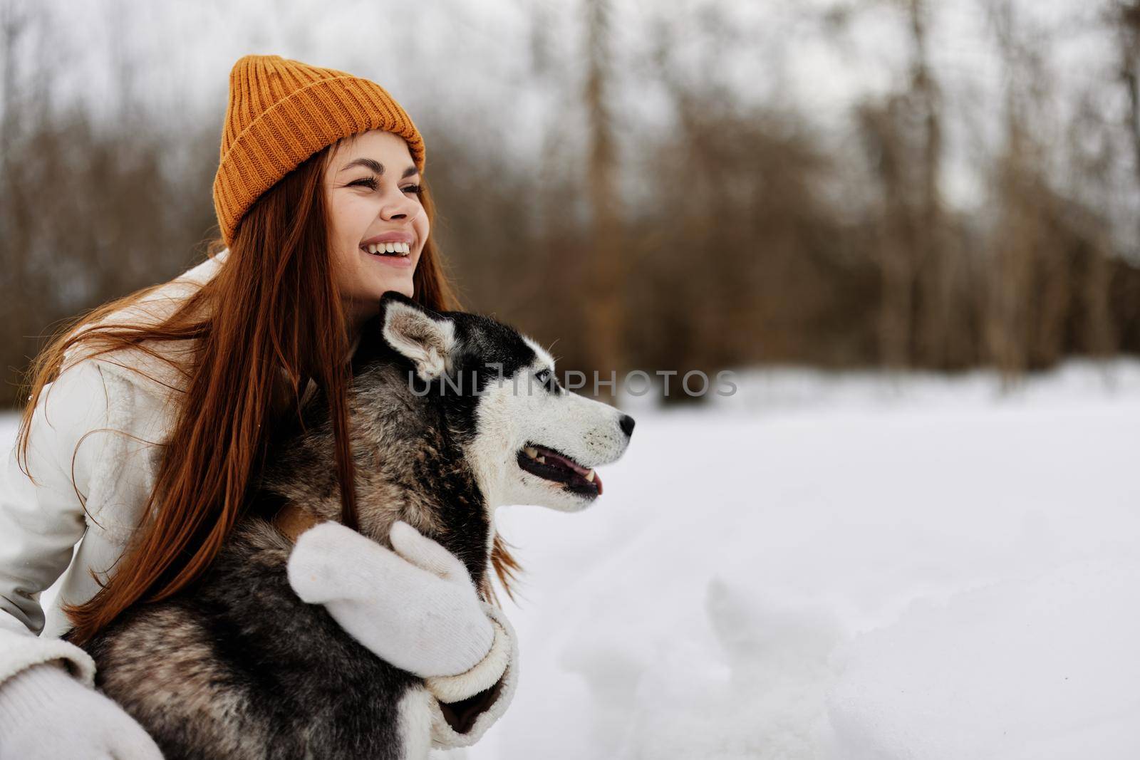 cheerful woman winter clothes walking the dog in the snow Lifestyle. High quality photo